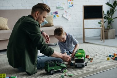 Far og søn der leger med legetøjsbiler